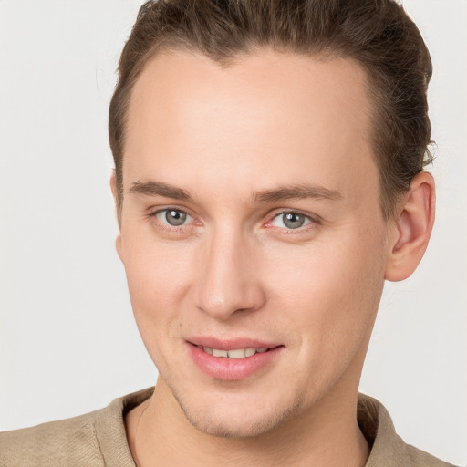 Joyful white young-adult male with short  brown hair and grey eyes