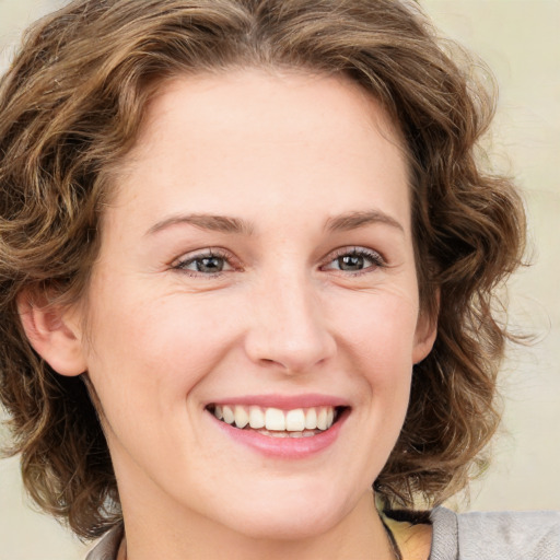 Joyful white young-adult female with medium  brown hair and green eyes