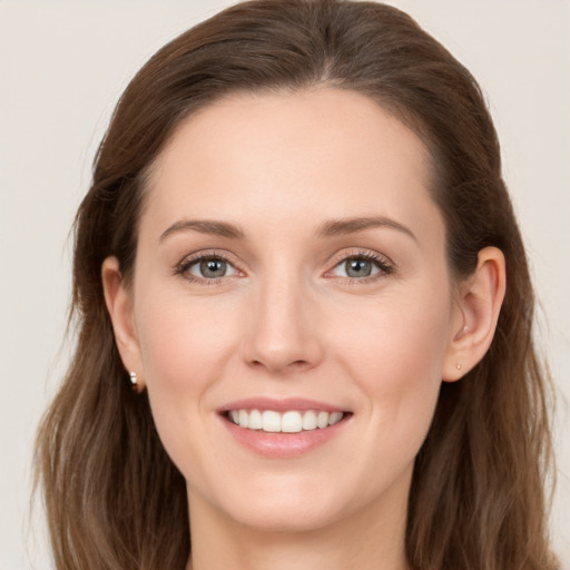 Joyful white young-adult female with long  brown hair and grey eyes