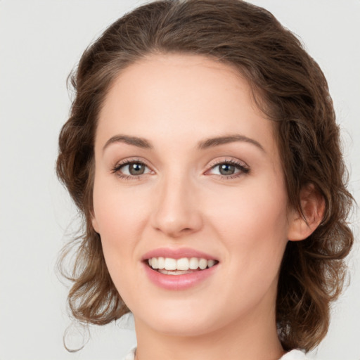 Joyful white young-adult female with medium  brown hair and green eyes