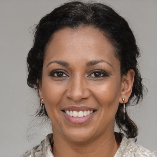Joyful latino adult female with medium  black hair and brown eyes