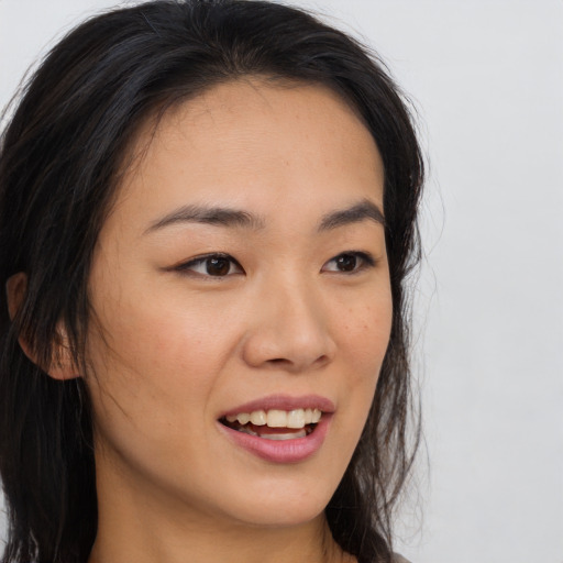 Joyful asian young-adult female with long  brown hair and brown eyes