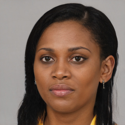 Joyful black young-adult female with long  black hair and brown eyes