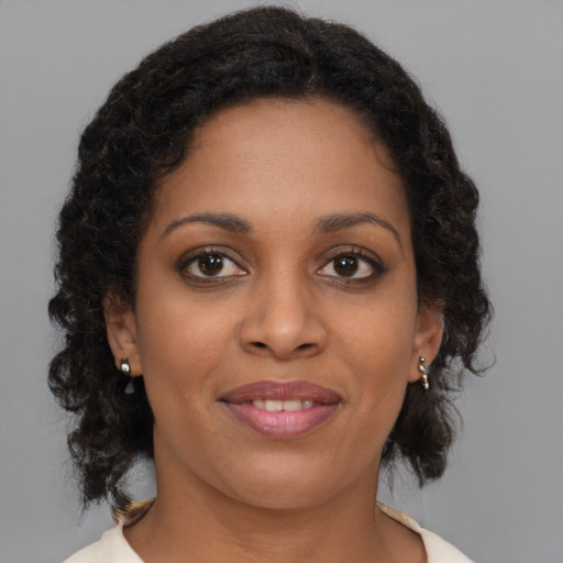 Joyful black young-adult female with long  brown hair and brown eyes