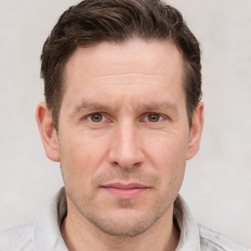 Joyful white adult male with short  brown hair and grey eyes