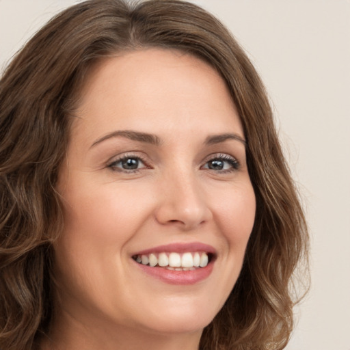 Joyful white young-adult female with long  brown hair and green eyes