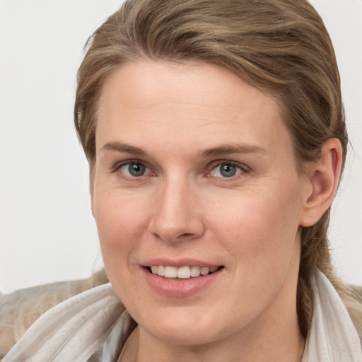 Joyful white young-adult female with long  brown hair and blue eyes