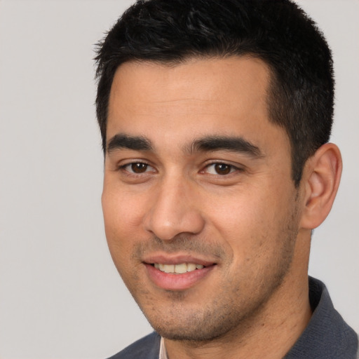 Joyful white young-adult male with short  black hair and brown eyes
