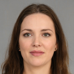 Joyful white young-adult female with long  brown hair and brown eyes