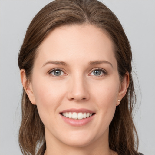 Joyful white young-adult female with long  brown hair and grey eyes