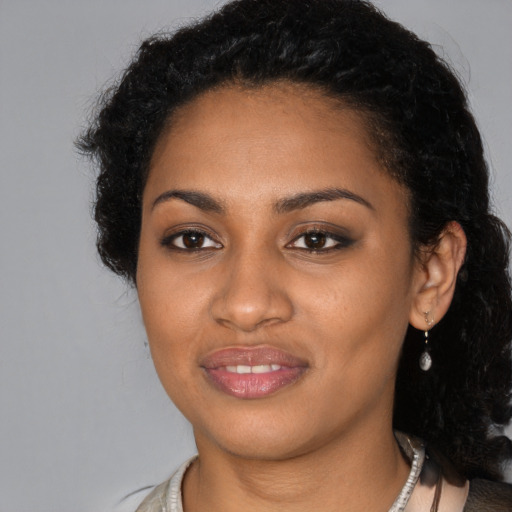 Joyful black young-adult female with long  black hair and brown eyes