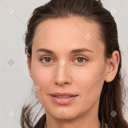 Joyful white young-adult female with long  brown hair and brown eyes