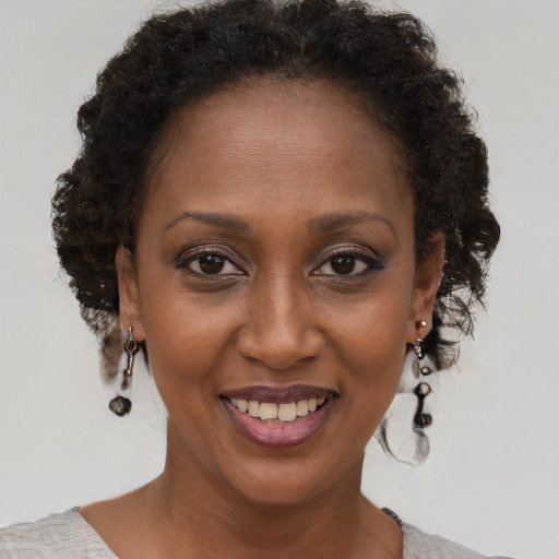 Joyful black adult female with short  brown hair and brown eyes