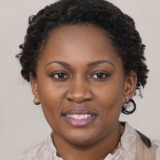 Joyful black adult female with short  brown hair and brown eyes