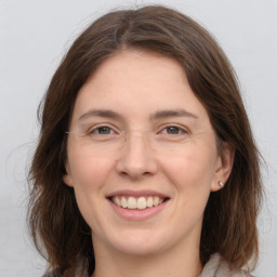 Joyful white young-adult female with medium  brown hair and grey eyes