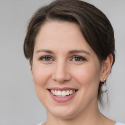 Joyful white young-adult female with medium  brown hair and grey eyes