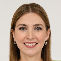 Joyful white young-adult female with long  brown hair and green eyes