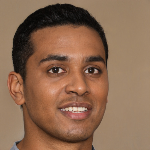 Joyful black young-adult male with short  brown hair and brown eyes