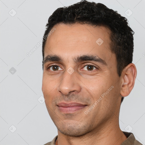 Joyful white adult male with short  black hair and brown eyes