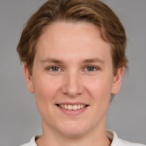 Joyful white young-adult female with short  brown hair and blue eyes