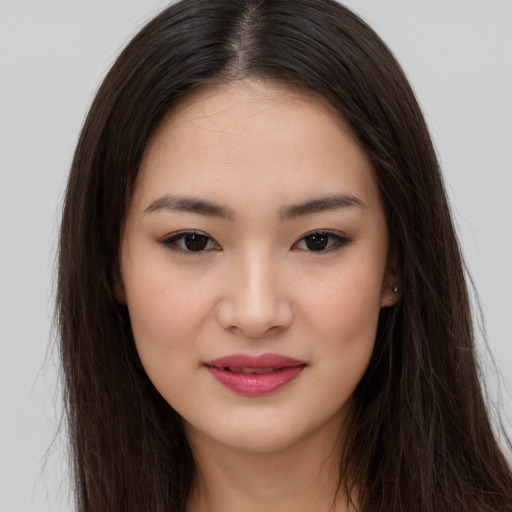 Joyful asian young-adult female with long  brown hair and brown eyes