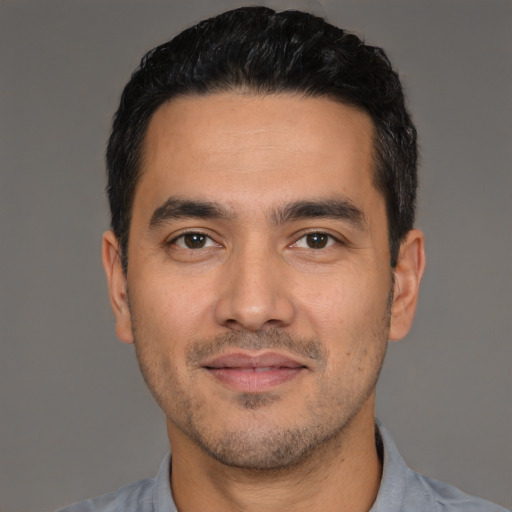 Joyful latino young-adult male with short  black hair and brown eyes