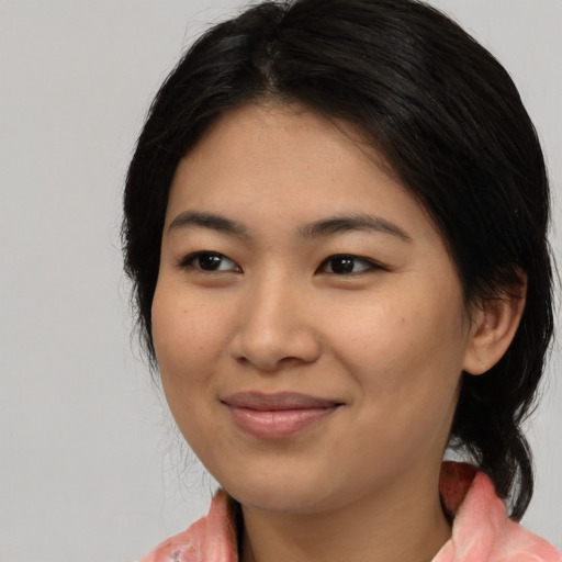 Joyful asian young-adult female with medium  brown hair and brown eyes
