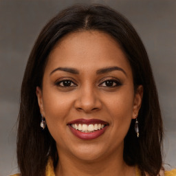 Joyful black young-adult female with long  brown hair and brown eyes