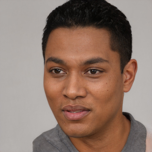 Joyful black young-adult male with short  black hair and brown eyes