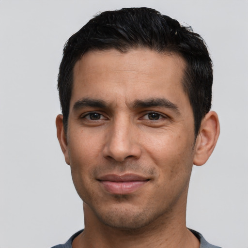 Joyful white young-adult male with short  black hair and brown eyes