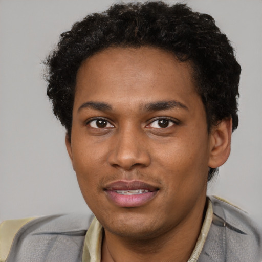 Joyful black young-adult male with short  brown hair and brown eyes