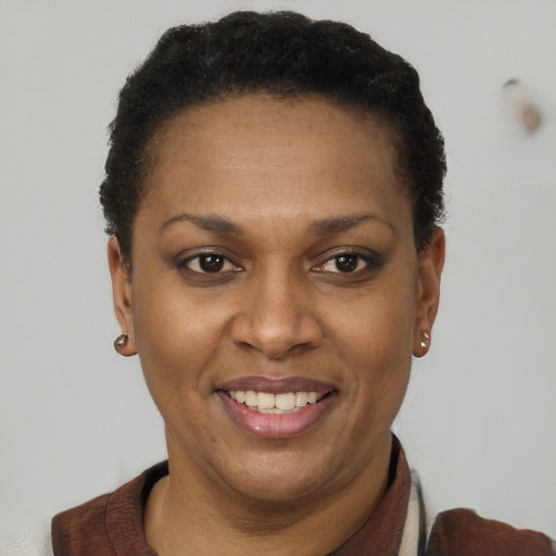 Joyful black adult female with short  brown hair and brown eyes