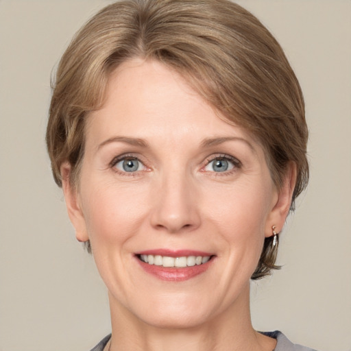 Joyful white adult female with medium  brown hair and grey eyes