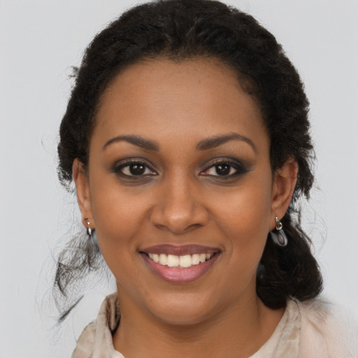 Joyful black young-adult female with long  brown hair and brown eyes