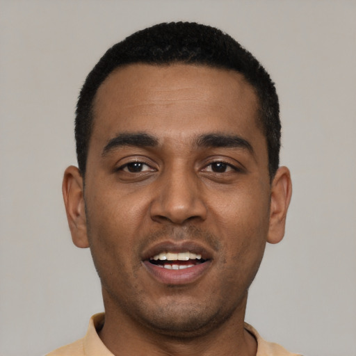 Joyful black young-adult male with short  black hair and brown eyes