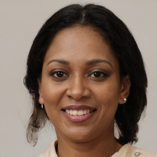 Joyful black adult female with medium  brown hair and brown eyes