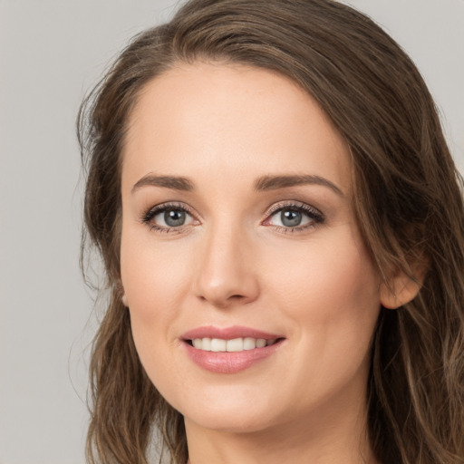 Joyful white young-adult female with long  brown hair and green eyes