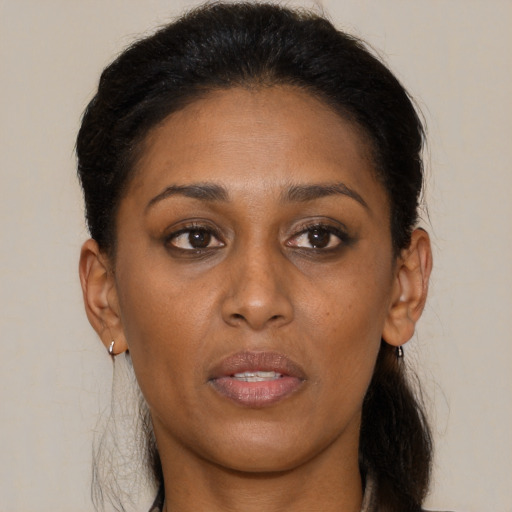 Joyful black young-adult female with long  brown hair and brown eyes