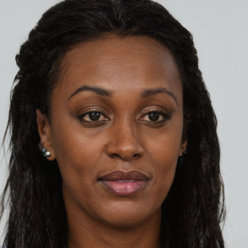 Joyful black adult female with long  brown hair and brown eyes