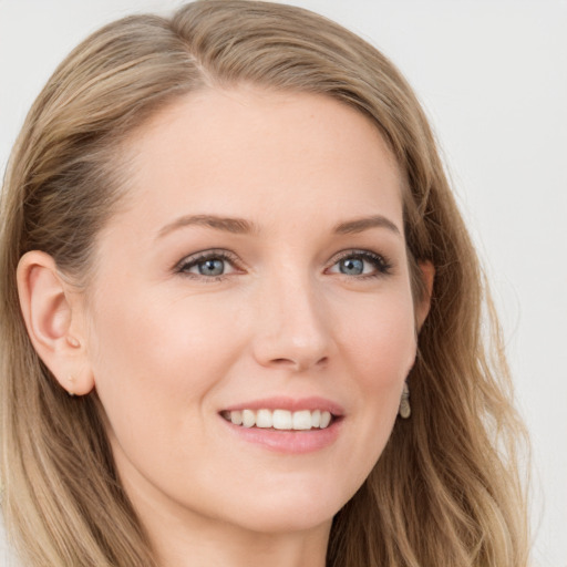 Joyful white young-adult female with long  brown hair and blue eyes