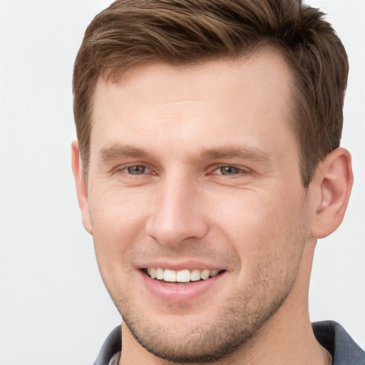 Joyful white young-adult male with short  brown hair and grey eyes