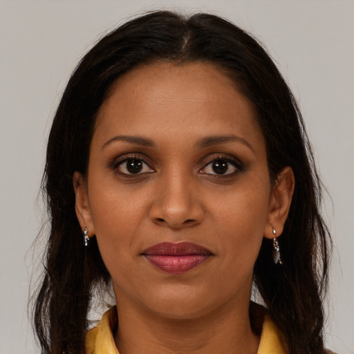 Joyful black young-adult female with long  brown hair and brown eyes