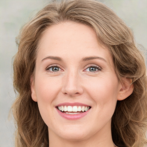 Joyful white young-adult female with long  brown hair and green eyes