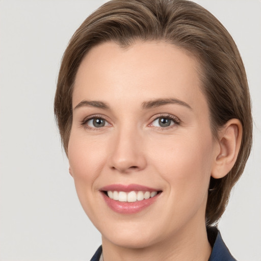 Joyful white young-adult female with medium  brown hair and grey eyes