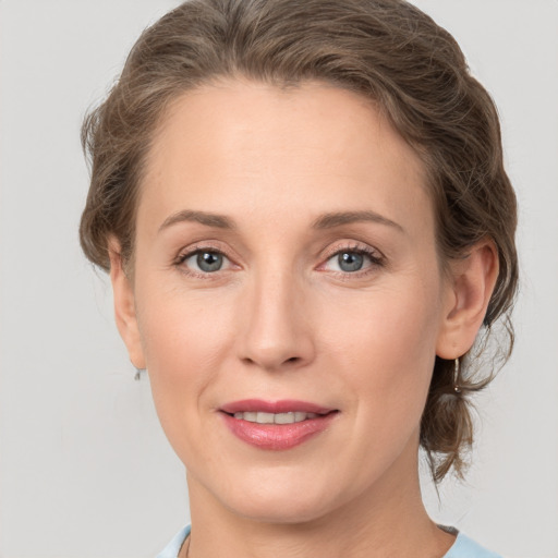 Joyful white adult female with medium  brown hair and grey eyes