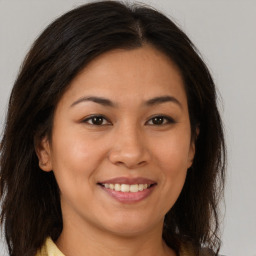 Joyful latino young-adult female with long  brown hair and brown eyes