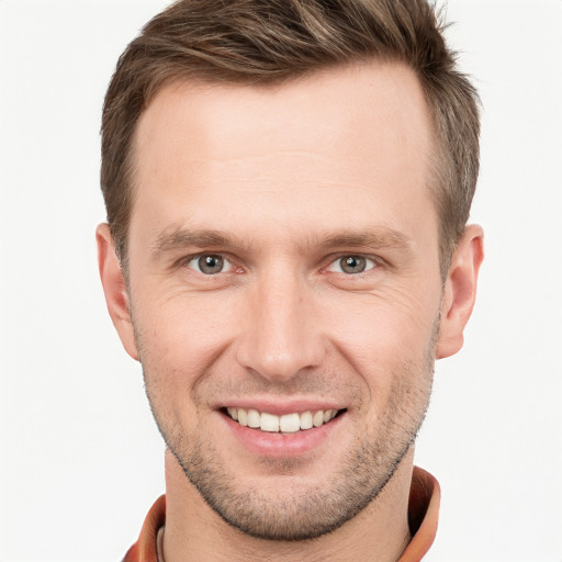 Joyful white young-adult male with short  brown hair and grey eyes