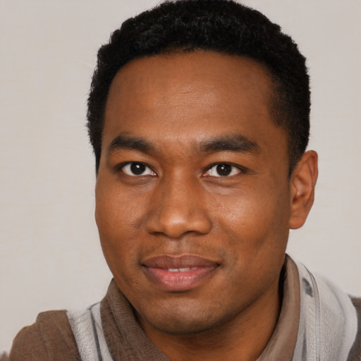 Joyful black young-adult male with short  black hair and brown eyes