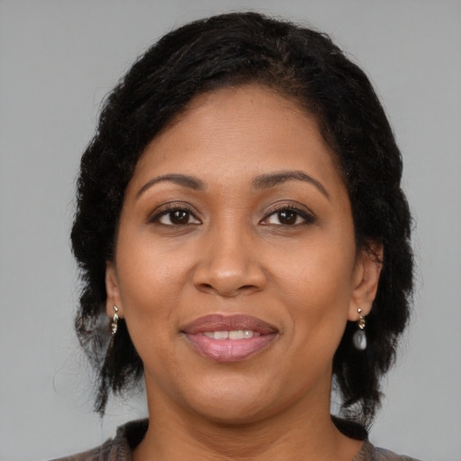 Joyful black adult female with medium  brown hair and brown eyes