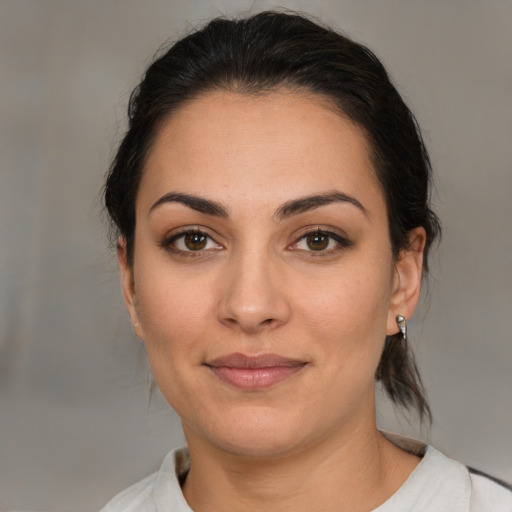 Joyful latino young-adult female with medium  brown hair and brown eyes